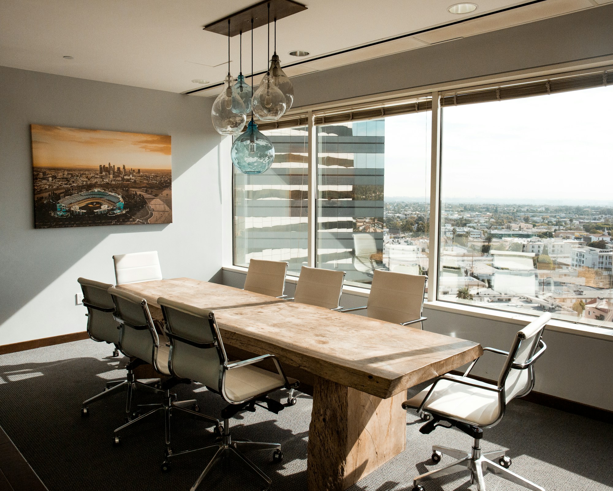 A beige wooden conference table in a daylit room.