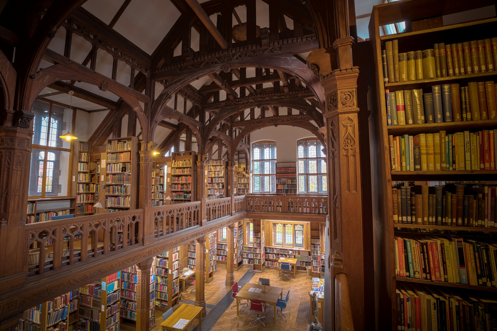 Interior of a grand library with wooden beams and bookshelves.
